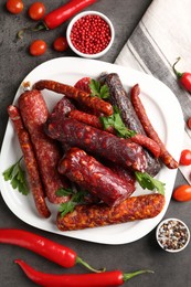 Photo of Flat lay composition with different smoked sausages and peppercorns on grey textured table