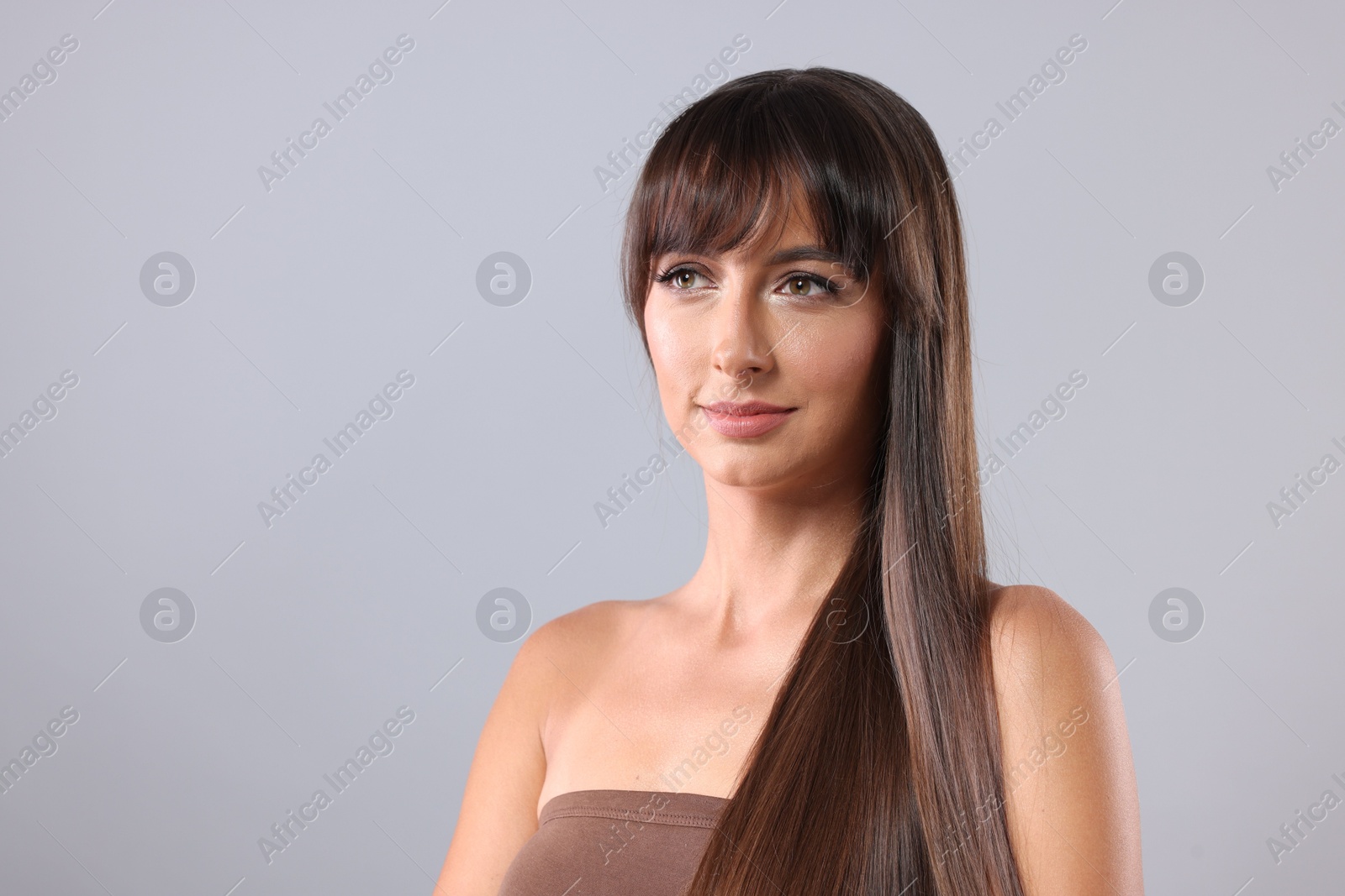 Photo of Hair styling. Beautiful woman with straight long hair on grey background, space for text