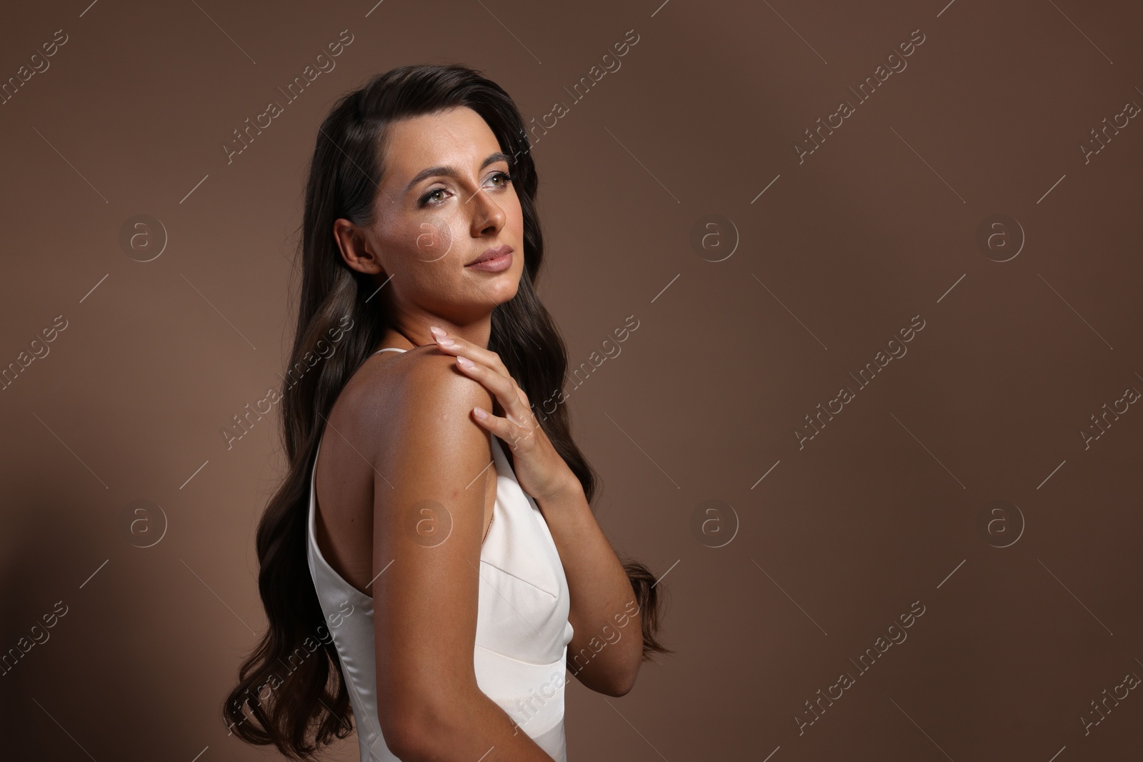 Photo of Hair styling. Beautiful woman with wavy long hair on brown background, space for text