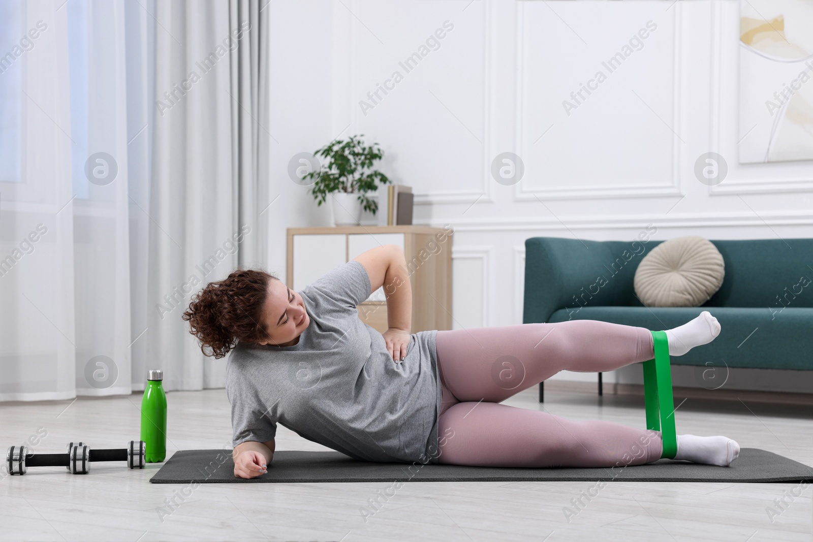 Photo of Woman training with resistance band at home