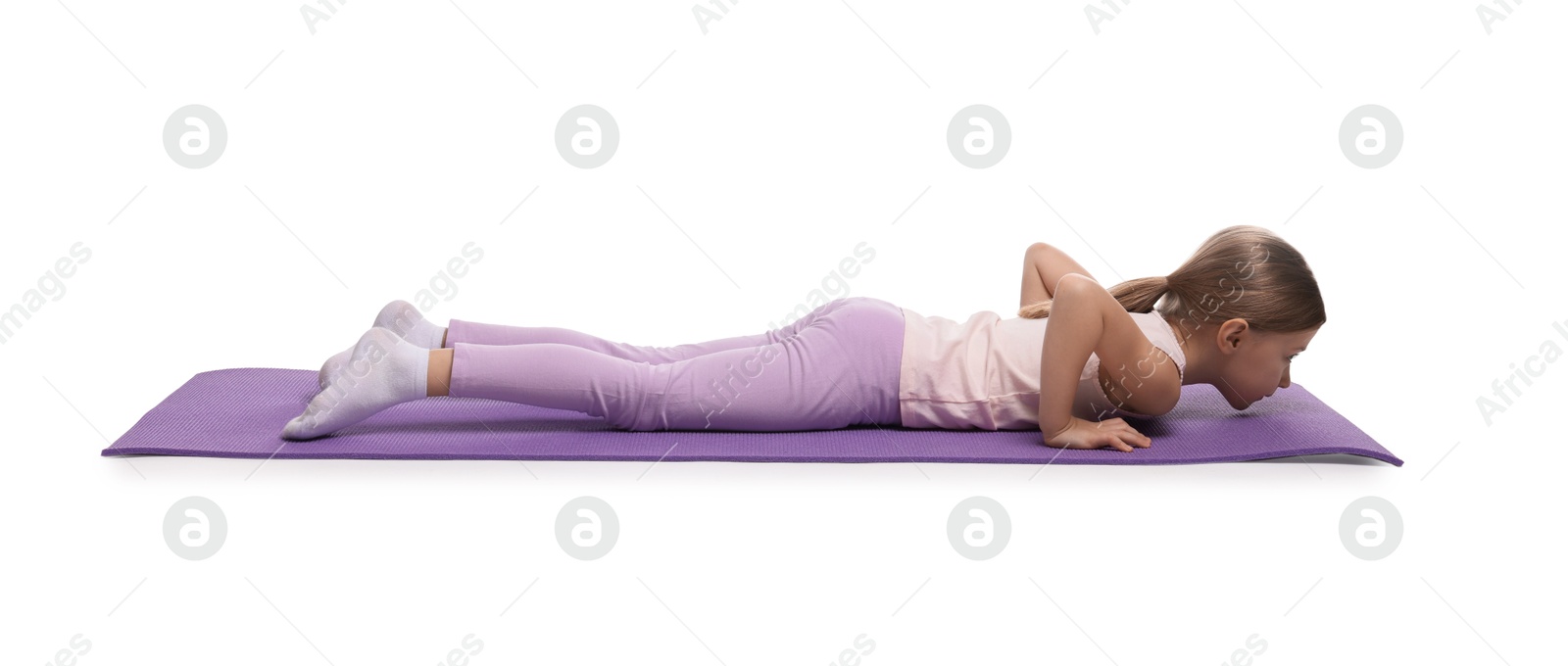 Photo of Little girl exercising on fitness mat against white background