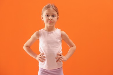 Photo of Little girl in sportswear on orange background