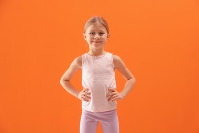 Photo of Little girl in sportswear on orange background