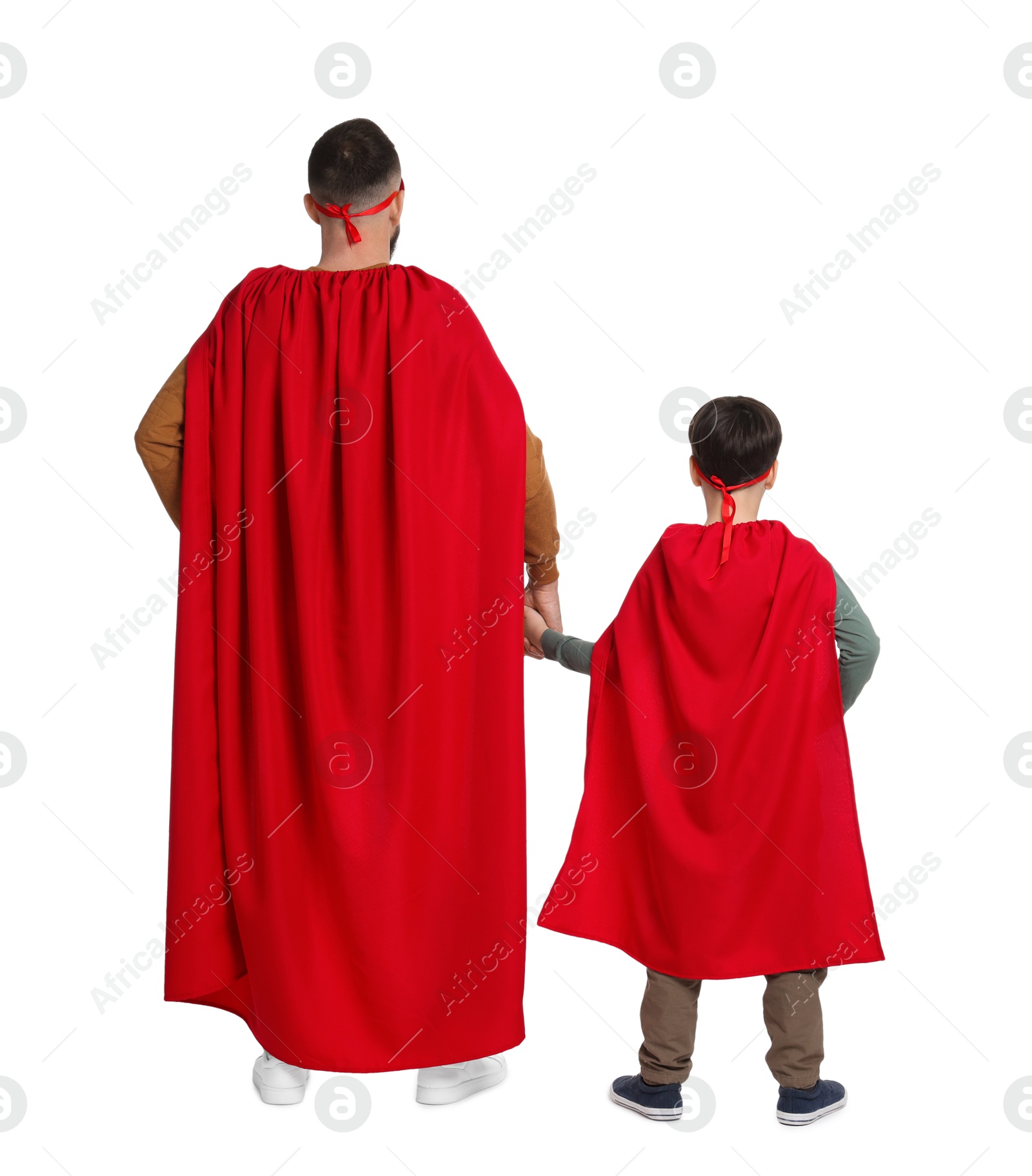 Photo of Father and his son wearing superhero costumes on white background, back view