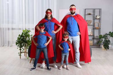 Photo of Parents and their children wearing superhero costumes at home