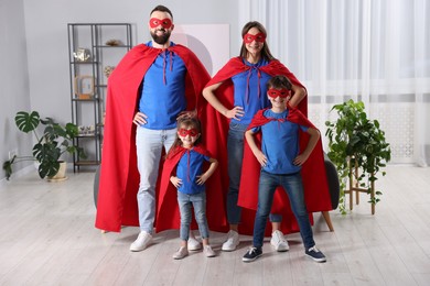 Photo of Parents and their children wearing superhero costumes at home