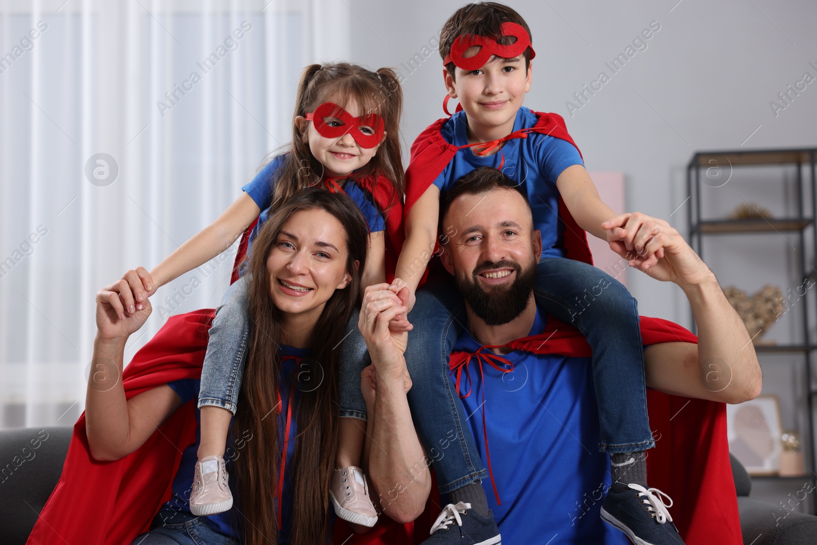 Photo of Parents and their children wearing superhero costumes at home