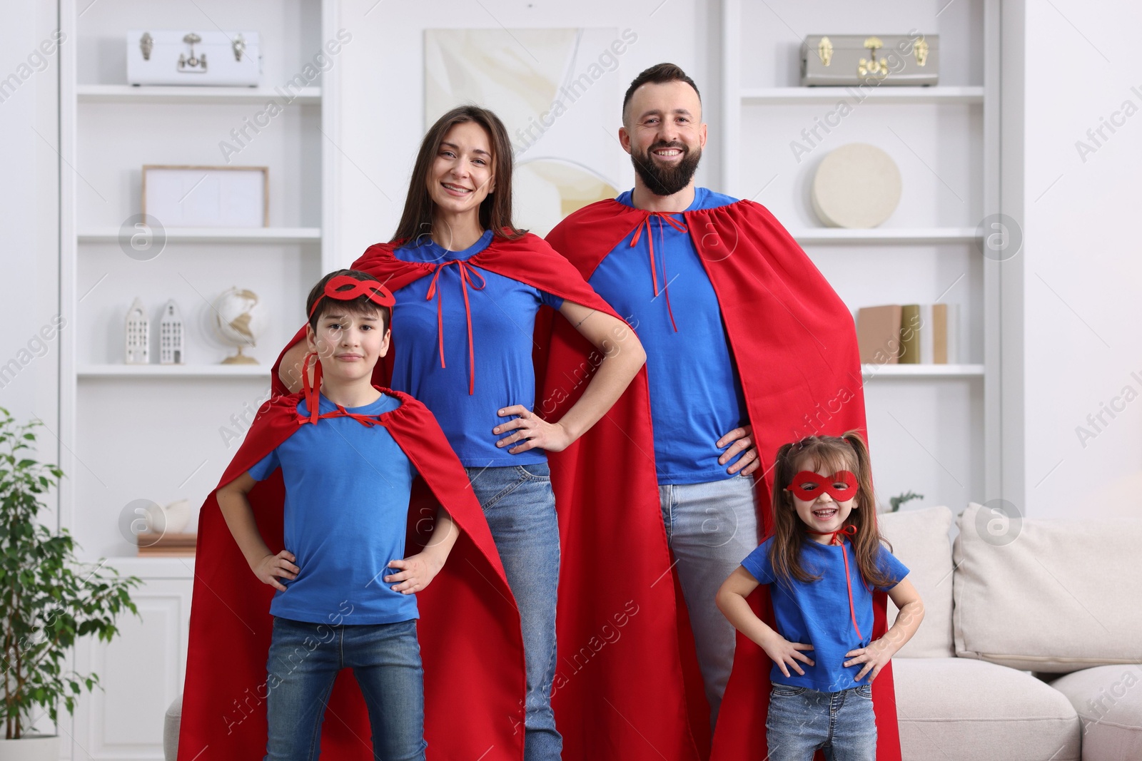 Photo of Parents and their children wearing superhero costumes at home