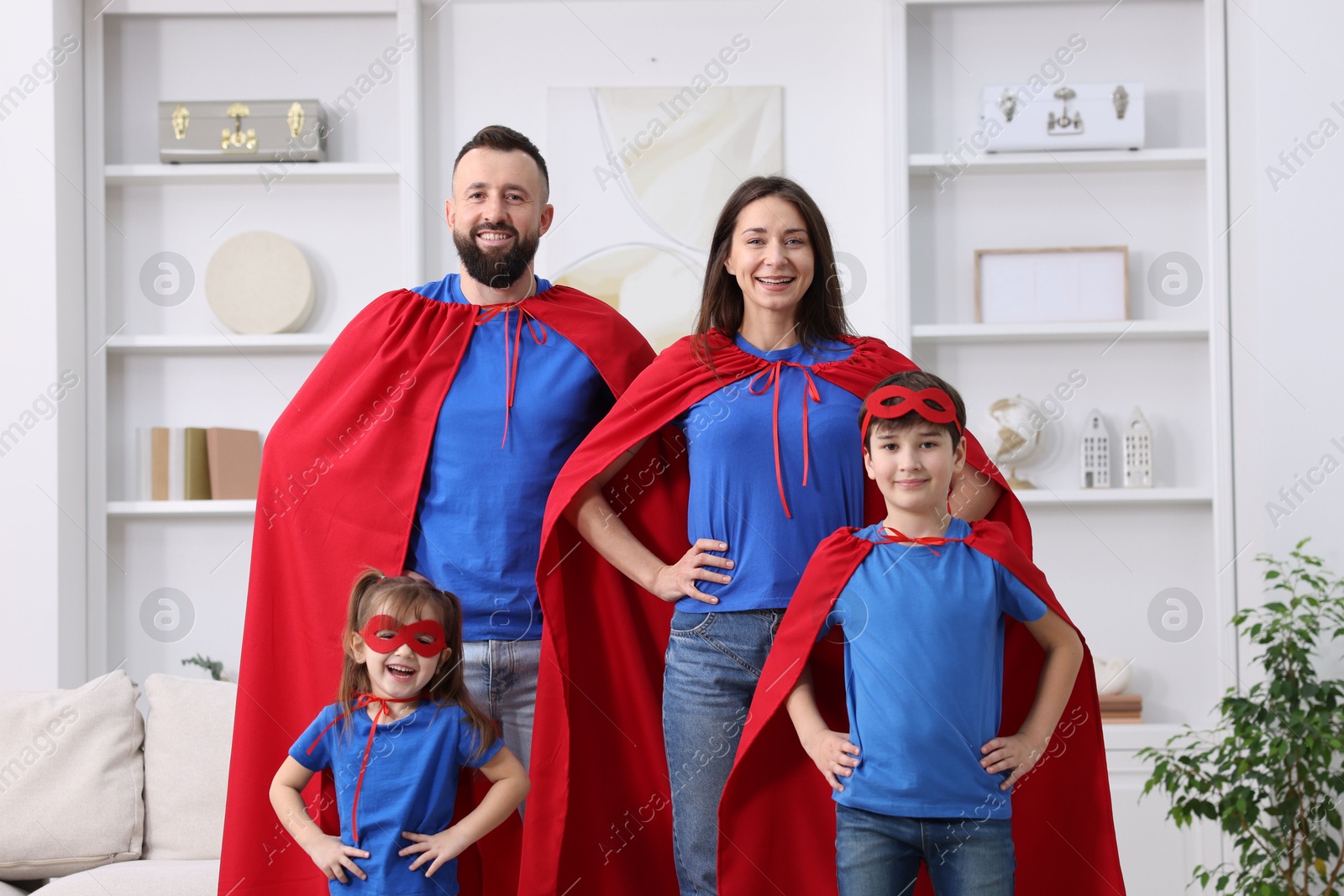 Photo of Parents and their children wearing superhero costumes at home