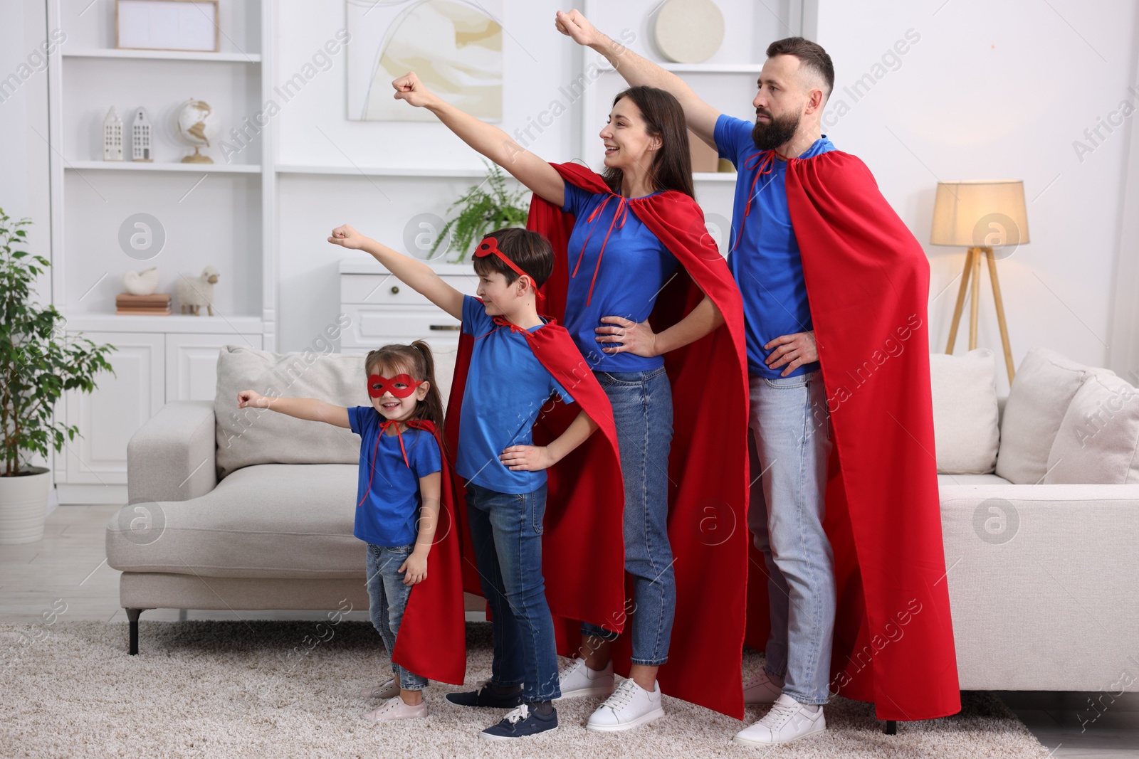 Photo of Parents and their children wearing superhero costumes at home