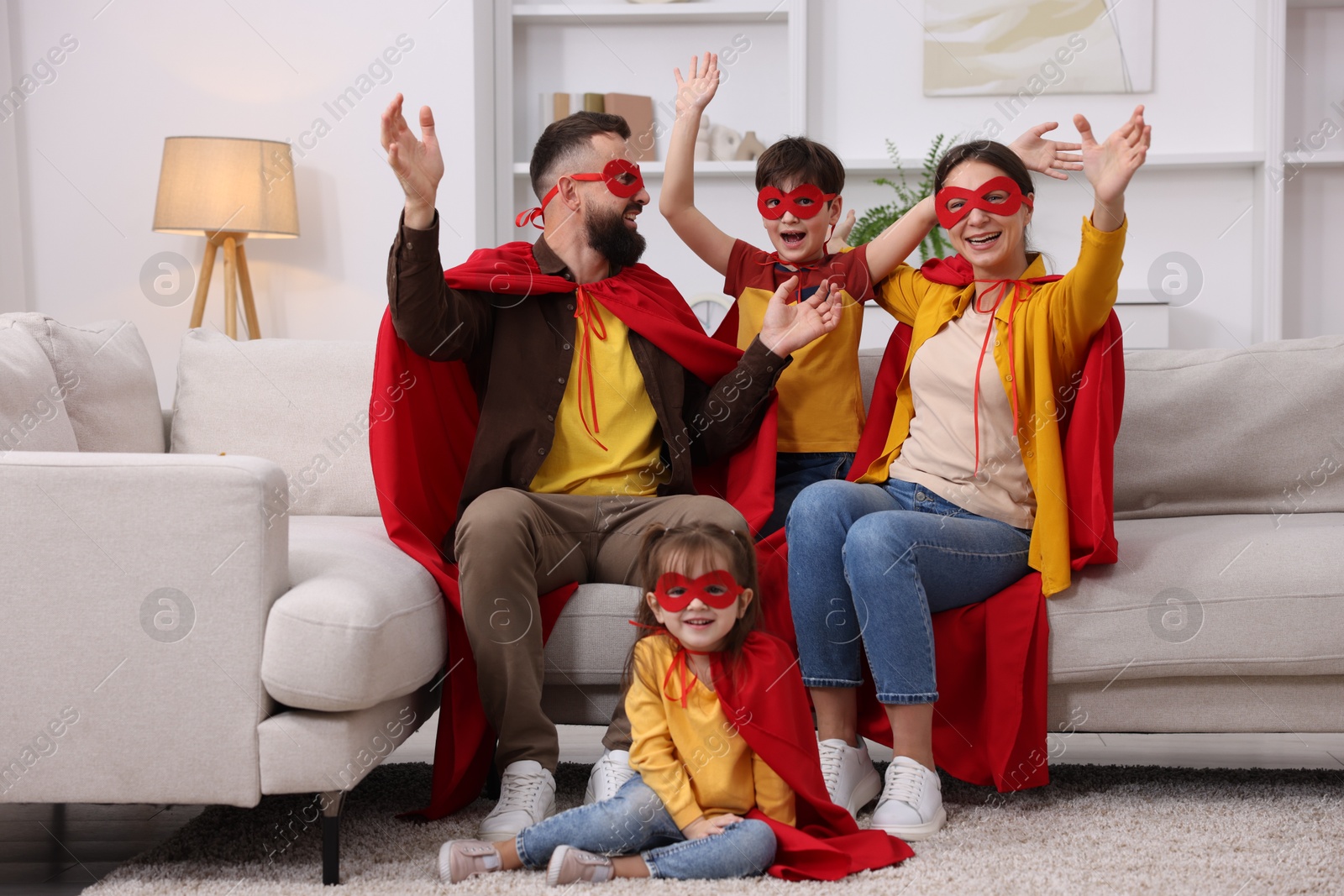 Photo of Parents and their children wearing superhero costumes at home