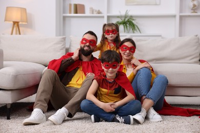 Photo of Parents and their children wearing superhero costumes at home