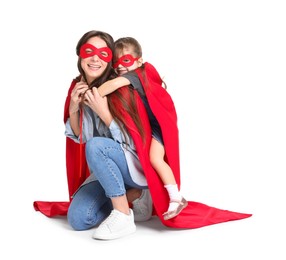 Photo of Mother and her cute little daughter wearing superhero costumes on white background