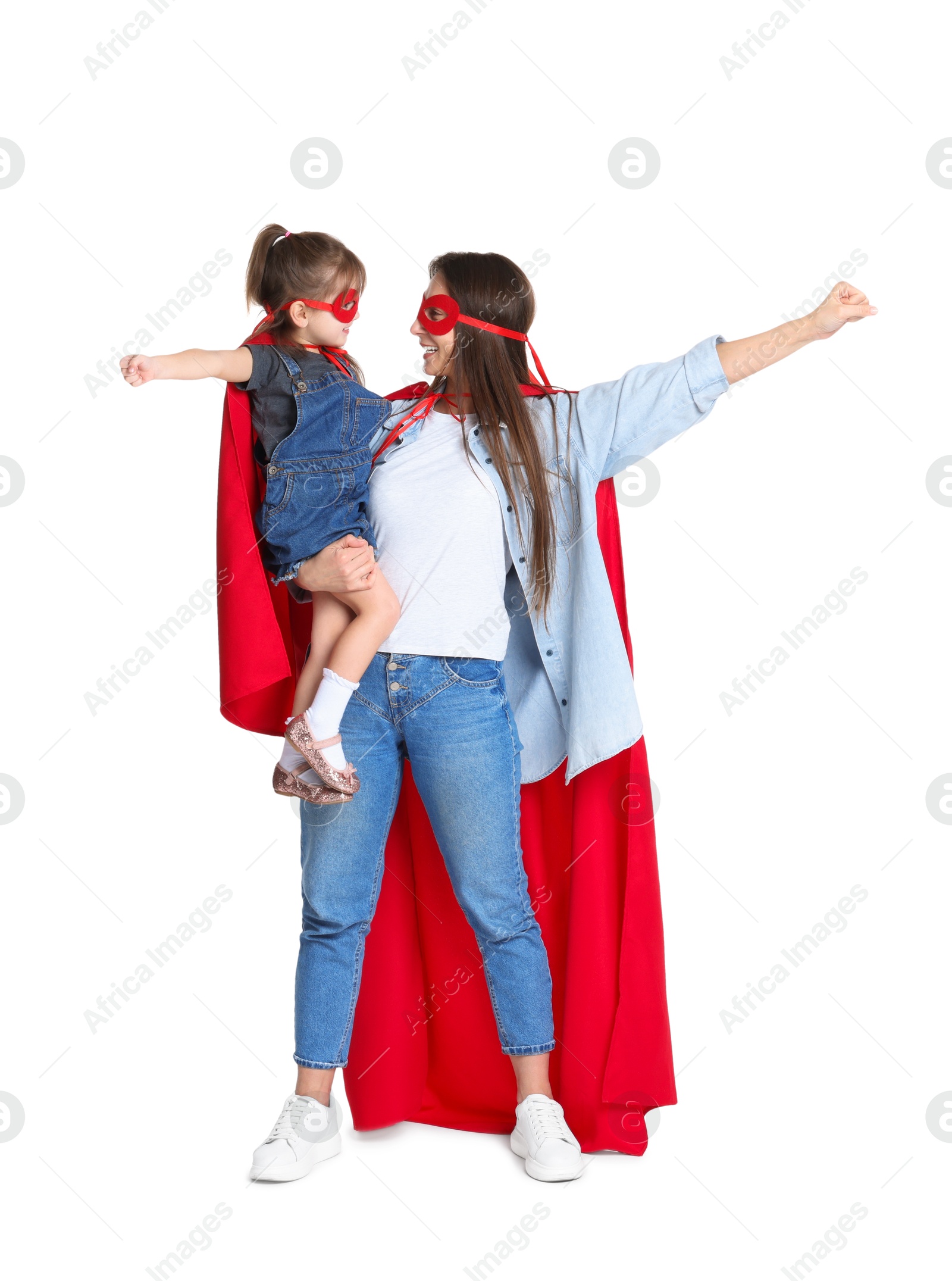 Photo of Mother and her cute little daughter wearing superhero costumes on white background