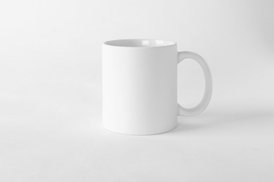 Photo of One blank mug on white background. Mockup for design