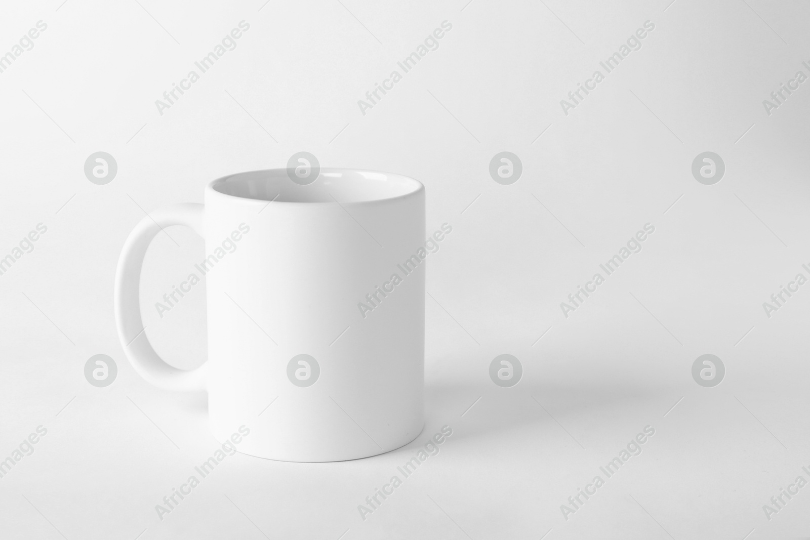 Photo of One blank mug on white background. Mockup for design