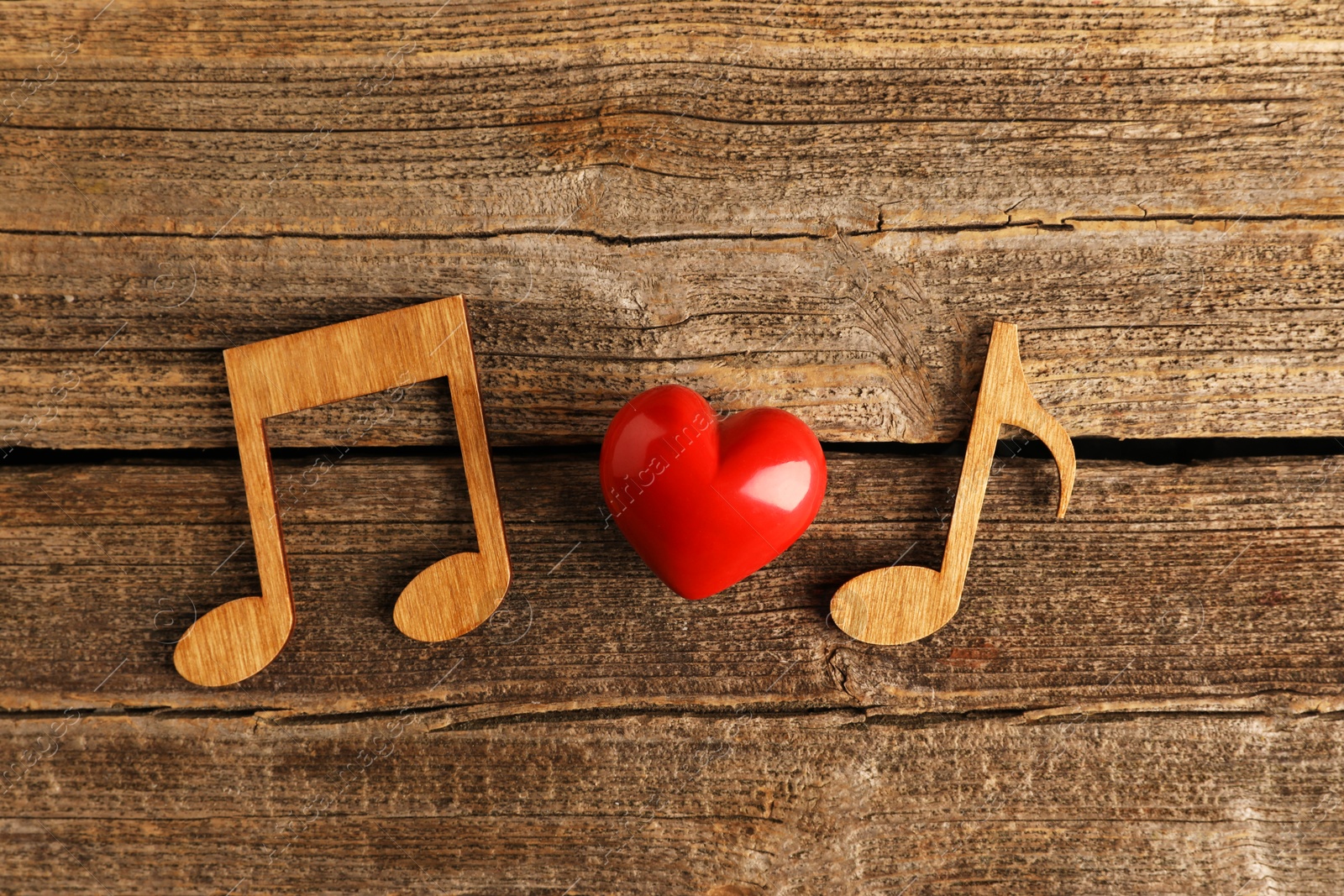 Photo of Red heart figure and notes on wooden table, flat lay