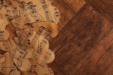 Photo of Paper hearts with notes on wooden table, flat lay. Space for text