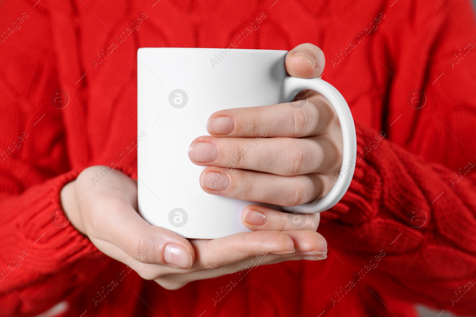 Photo of Woman holding blank white ceramic mug, closeup. Mockup for design