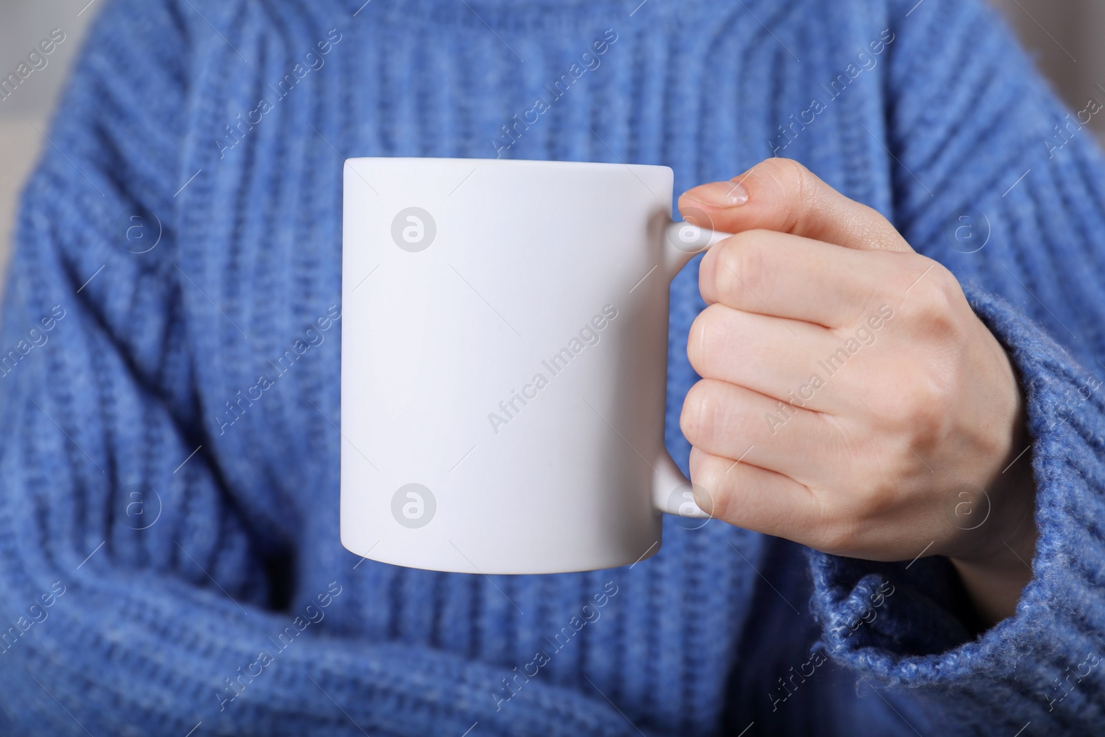 Photo of Woman holding blank white ceramic mug, closeup. Mockup for design