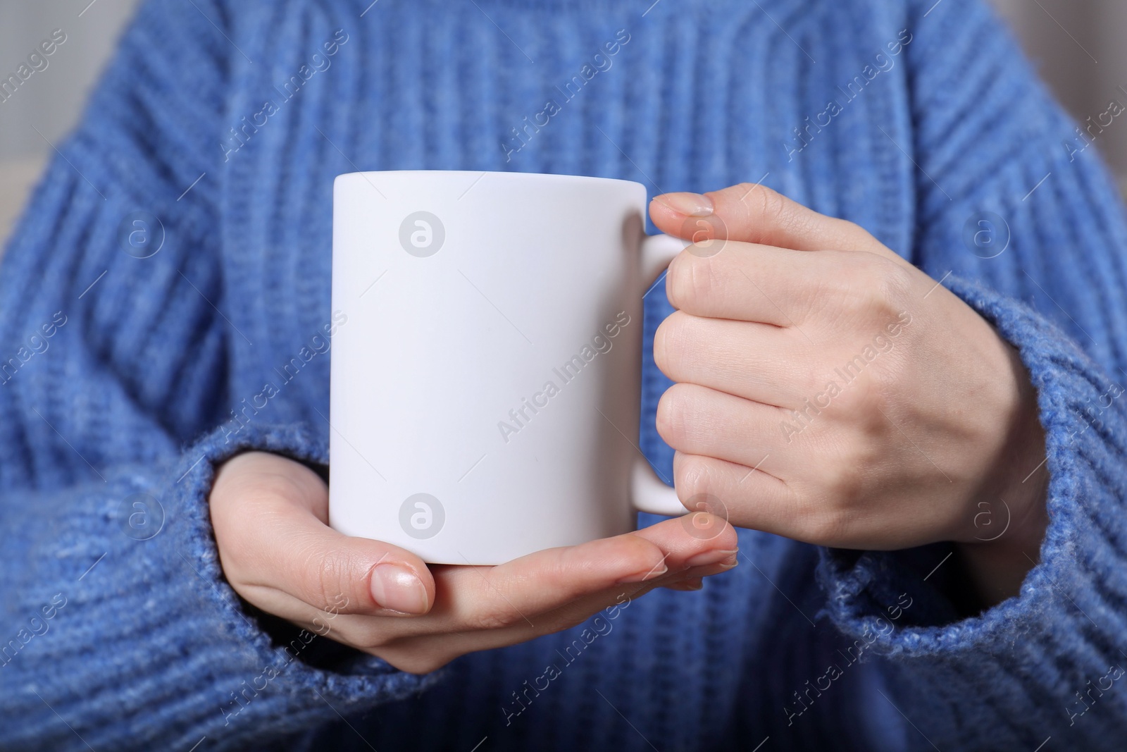 Photo of Woman holding blank white ceramic mug, closeup. Mockup for design