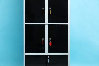 Photo of Modern lockers with keys on light blue background