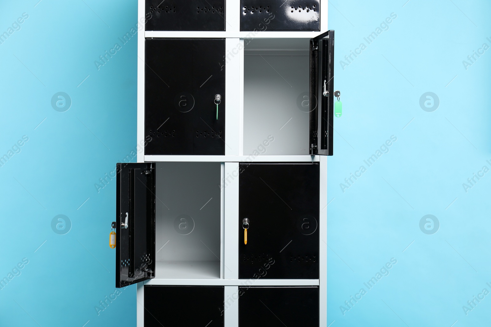 Photo of Modern lockers with keys on light blue background