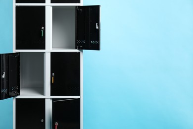 Modern lockers with keys on light blue background, space for text