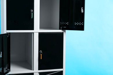 Modern lockers with keys on light blue background, space for text