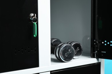 Photo of Open locker with metal dumbbells, closeup view