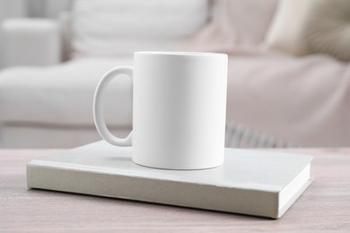 Photo of Blank ceramic mug and notebook on wooden table. Mockup for design