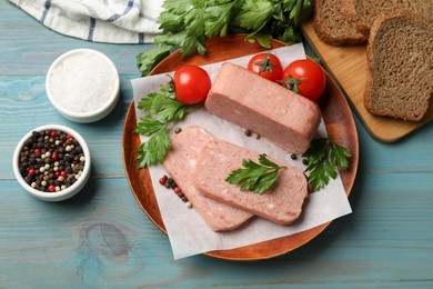 Photo of Pieces of tasty canned meat, parsley, spices and tomatoes on light blue wooden table, flat lay