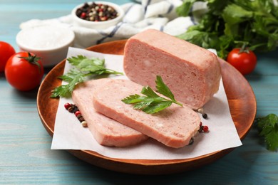 Pieces of tasty canned meat, parsley and peppercorns on light blue wooden table, closeup