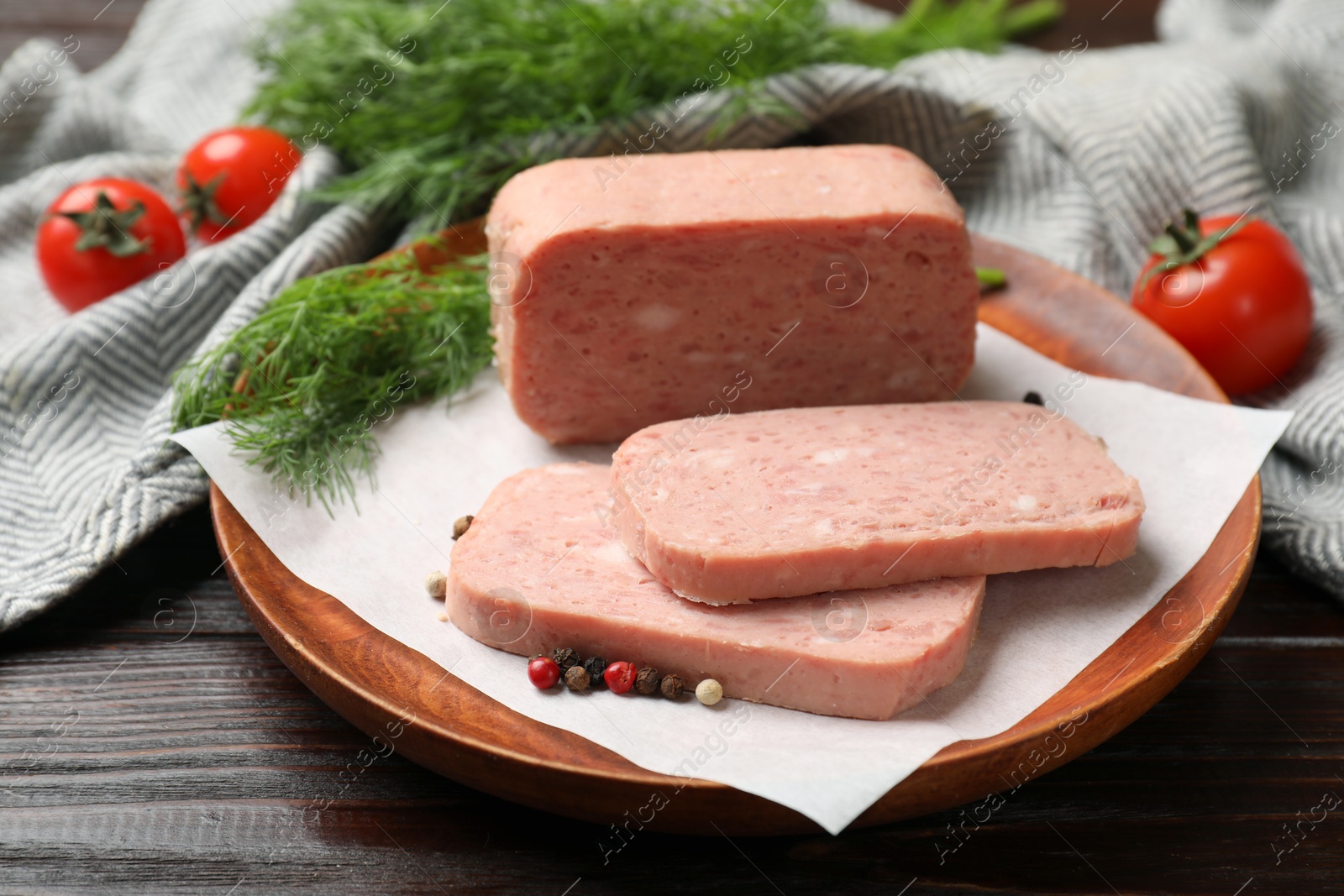 Photo of Pieces of tasty canned meat and peppercorns on wooden table, closeup