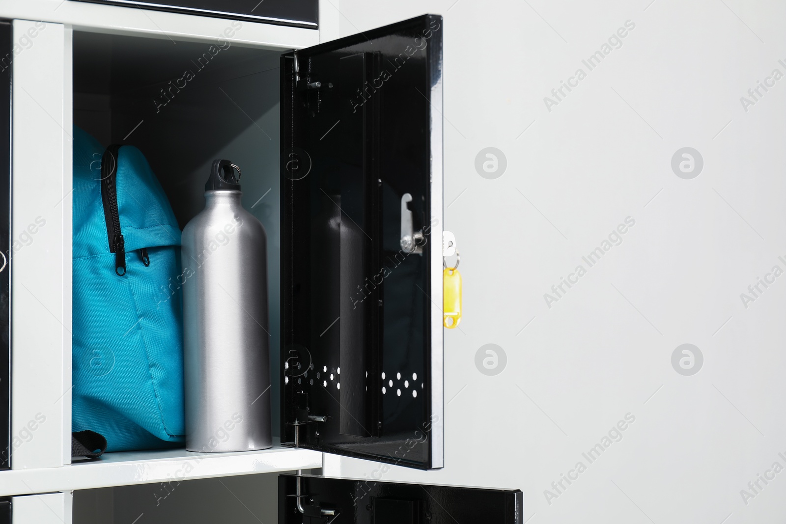 Photo of Lockers with personal belongings in changing room at gym, closeup