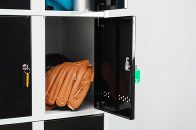 Photo of Lockers with personal belongings in changing room at gym, closeup