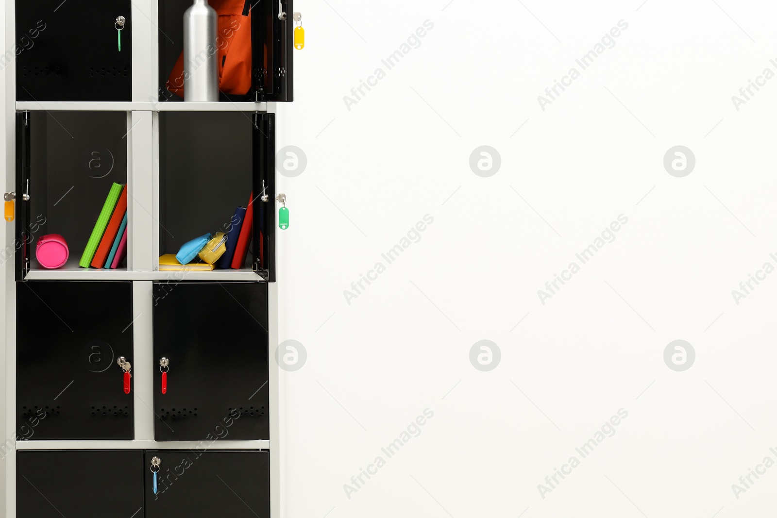 Photo of Lockers with school supplies on light background, closeup. Space for text