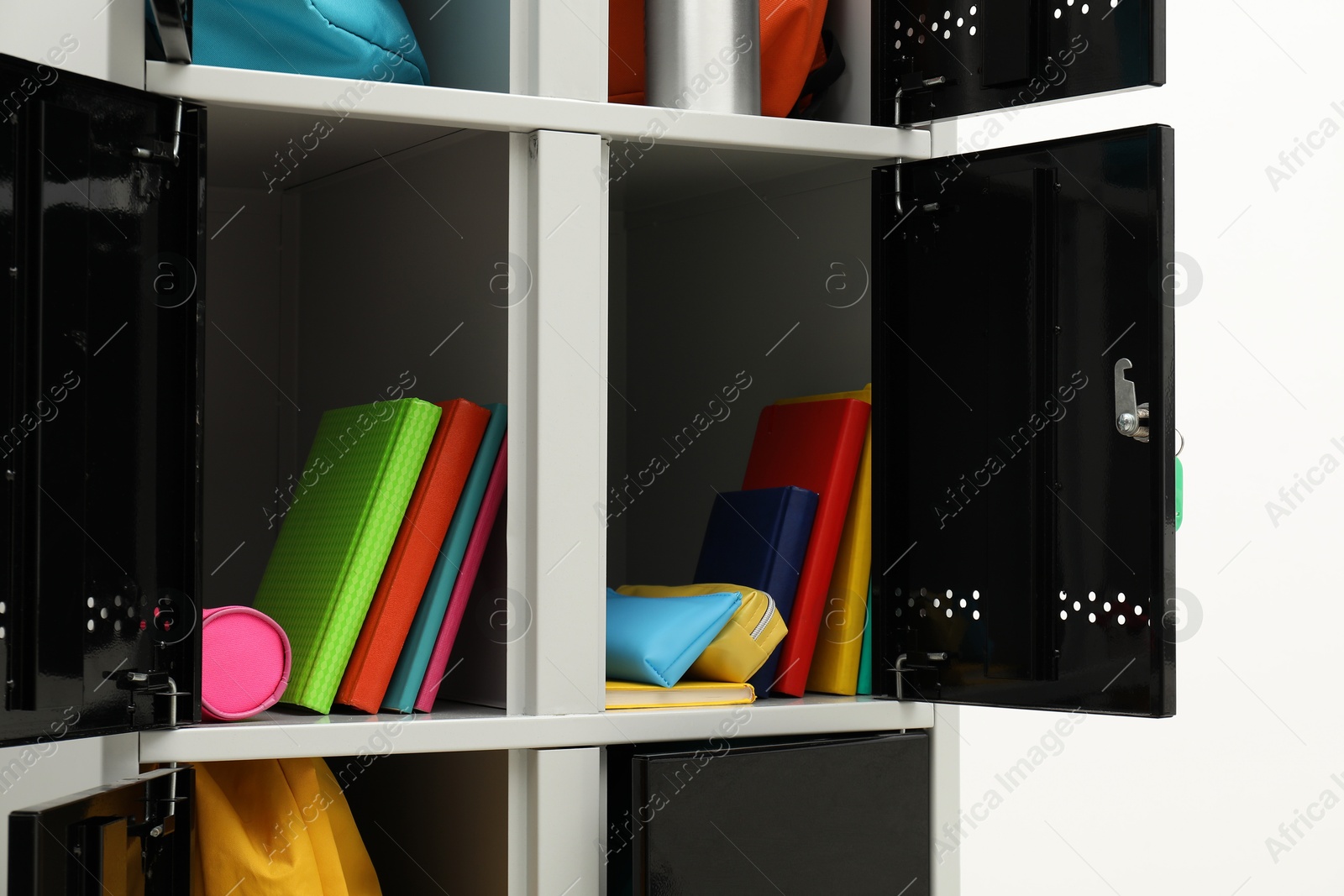 Photo of Lockers with school supplies on light background, closeup