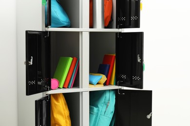 Photo of Lockers with school supplies on light background, closeup