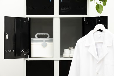 Photo of Medical personnel uniform on locker in changing room, closeup