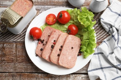 Photo of Tasty canned meat, tomatoes, lettuce and spices on wooden table, top view