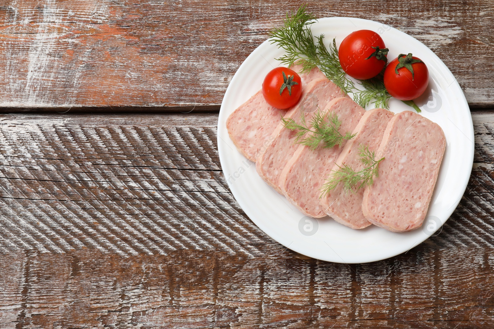 Photo of Tasty canned meat, tomatoes and dill on wooden table, top view. Space for text