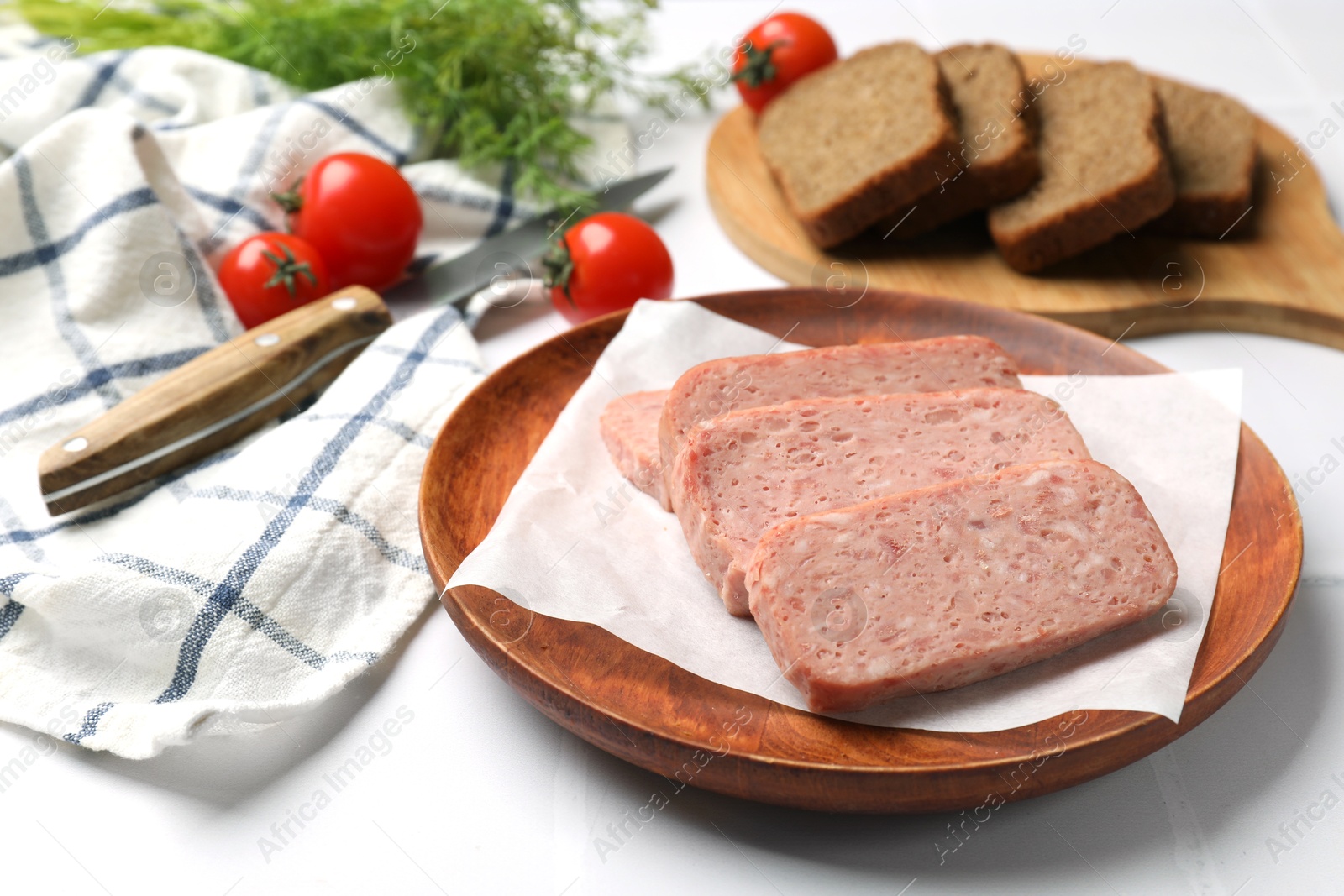 Photo of Canned meat, bread and tomatoes on white tiled table, closeup