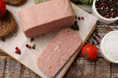 Photo of Canned meat, spices, tomatoes and bread on wooden table, flat lay