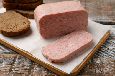 Photo of Canned meat and bread on wooden table, closeup