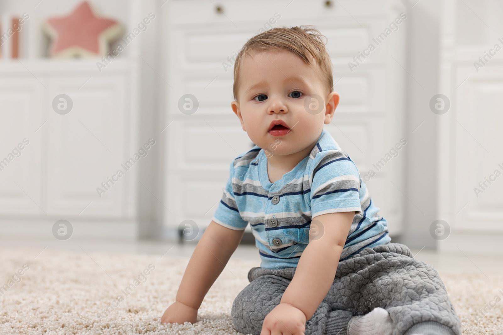 Photo of Adorable baby boy on floor at home