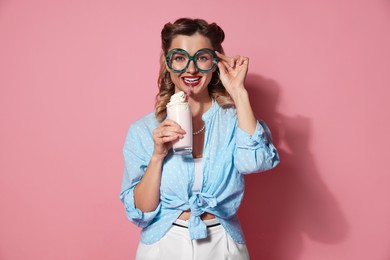 Photo of Happy pin-up woman with milk shake on pink background