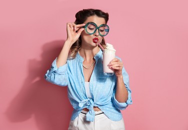 Photo of Attractive pin-up woman with milk shake on pink background