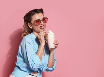 Photo of Happy pin-up woman with milk shake on pink background. Space for text