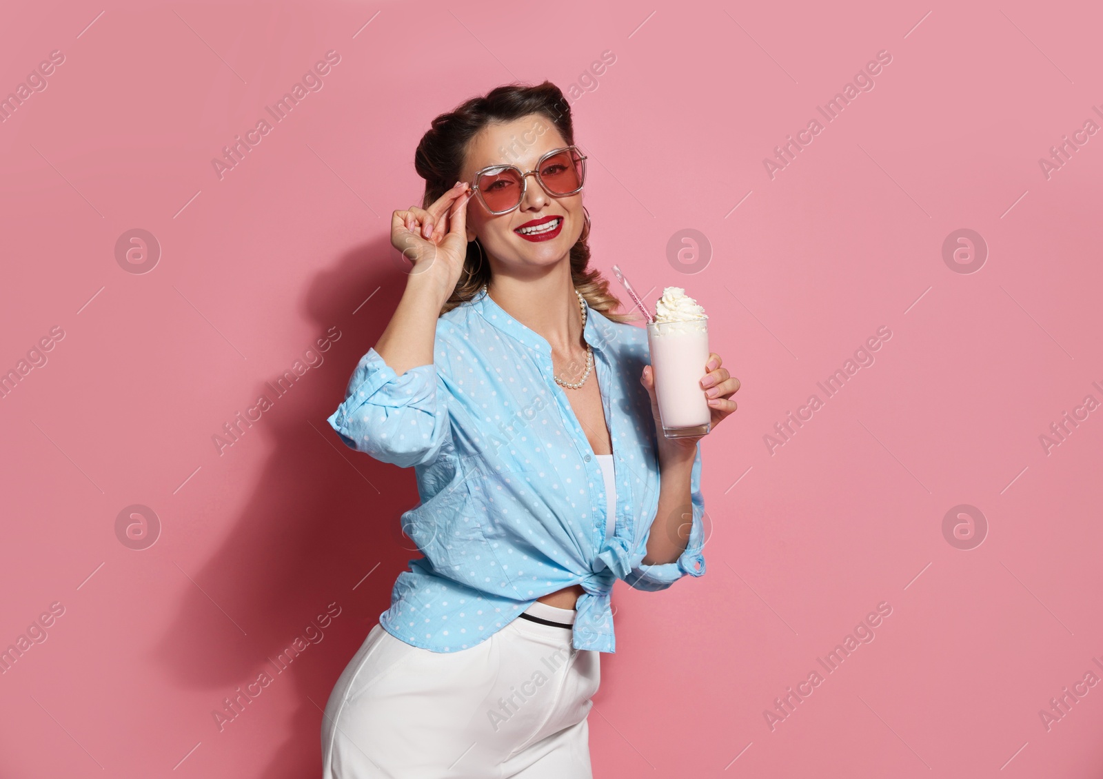 Photo of Happy pin-up woman with milk shake on pink background